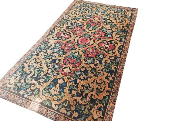 Ornate gold and red floral motifs cover the dark navy field of this rectangular low-pile rug.