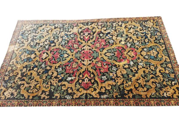 Ornate area rug featuring a black field with sprawling gold scrollwork and vibrant red floral motifs.