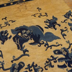 Textured yellow rug featuring dark blue stylized animal patterns and visible wear on distressed wooden floorboards.