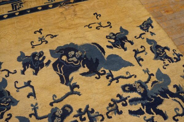 Textured yellow rug featuring dark blue stylized animal patterns and visible wear on distressed wooden floorboards.