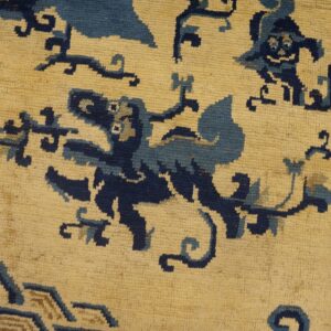 A textured, cream rug with blue and navy stylized patterns is visible beside distressed wood planks.