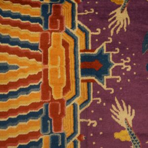 A purple, red, yellow, and blue patterned rug with dragon and geometric motifs borders a wooden floor.