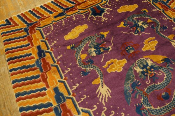 Purple rug featuring blue dragons, yellow clouds, and a multi-colored geometric border on wood flooring.