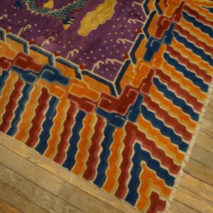 Purple rug with a yellow dragon and colorful blue, orange, and red wavy stripes resting on wooden planks.