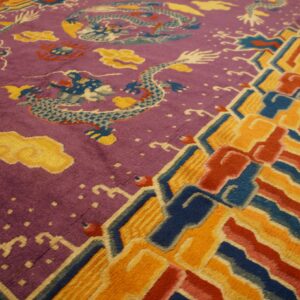 Purple rug section with blue dragon pattern meets a bright orange, red, and blue striped border.