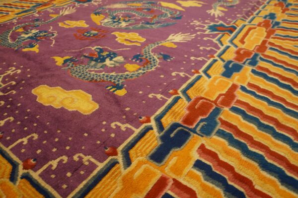 Purple rug section with blue dragon pattern meets a bright orange, red, and blue striped border.