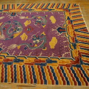 Purple dragon-patterned rug with bold red, blue, and gold borders lying on worn light wood flooring.