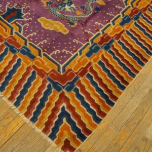 Purple rug with a blue dragon pattern and geometric borders in blue, orange, and red resting on wood flooring.