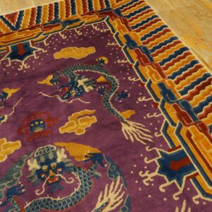Purple rug with blue dragon and yellow cloud pattern, framed by a colorful striped border on wood flooring.