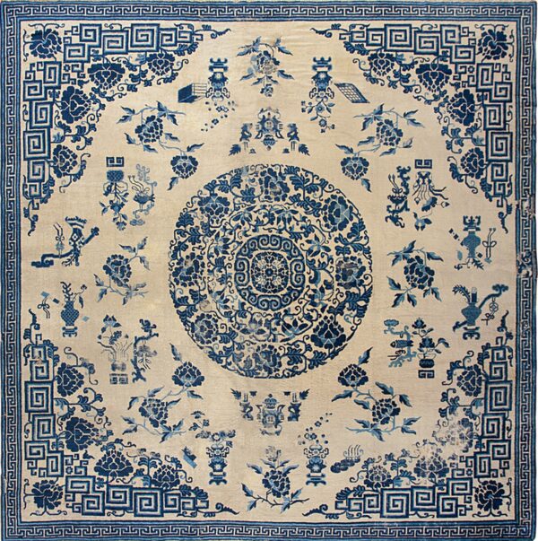 Intricate blue and cream rug with a central medallion and detailed geometric meander borders.