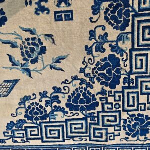 Cream field rug with deep blue floral patterns and Greek key border details.