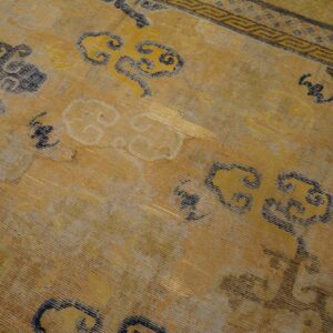 Gold and yellow rug featuring stylized blue and gray cloud motifs and a detailed geometric border.
