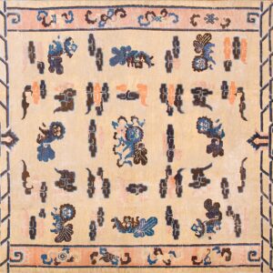 A light tan rug with indigo blue, coral, and brown folkloric designs and geometric borders.