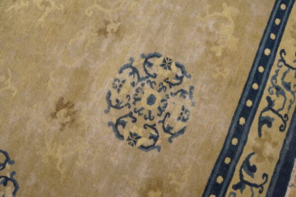 Distressed gold rug detailed with a central dark blue medallion and a vertical dotted border.