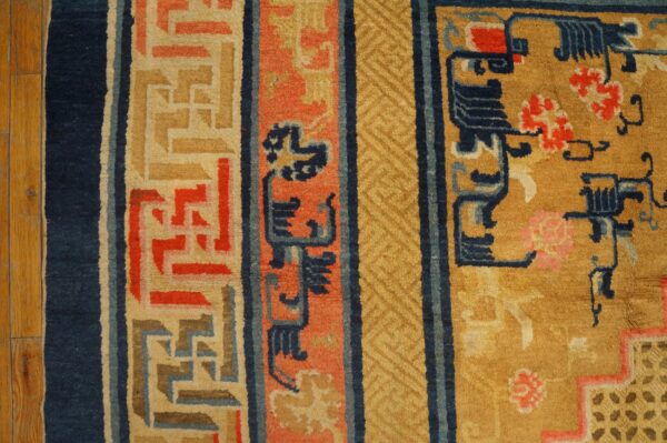 Plush rug border in navy, coral, and gold with geometric patterns rests on hardwood flooring.