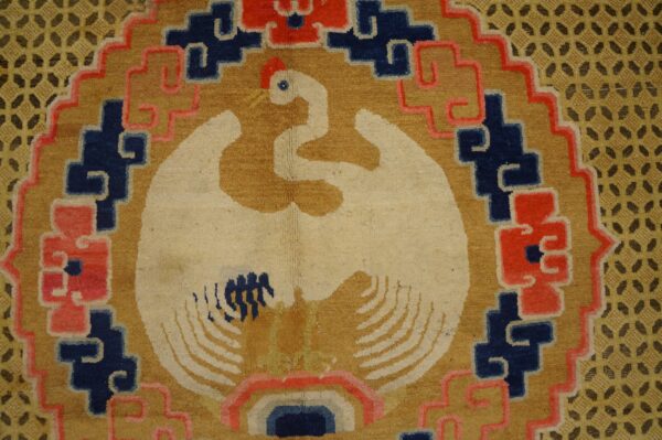 A high-pile rug detail shows a cream bird on gold, bordered by red, blue, and lattice patterns.