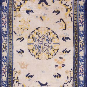 Ivory rug featuring a dark blue Greek key border and a central medallion with yellow and blue stylized designs.