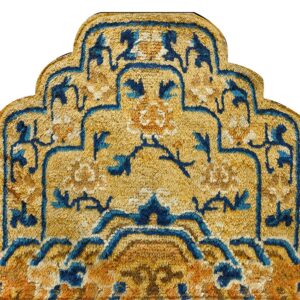 Textured high-pile rug section in gold, deep blue, and rust colors with an intricate curved medallion design.