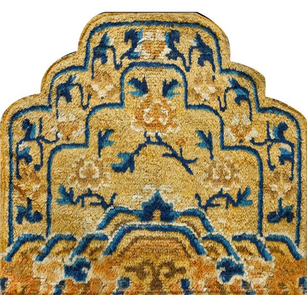 Textured high-pile rug section in gold, deep blue, and rust colors with an intricate curved medallion design.