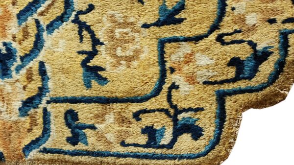 Shaggy rug close-up showing a high pile texture and abstract pattern in gold, blue, and brown.