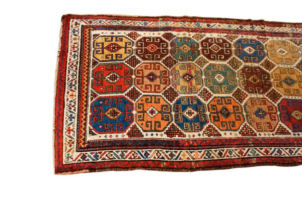 Intricately woven geometric rug featuring a pattern of octagons in red, blue, teal, orange, and brown.