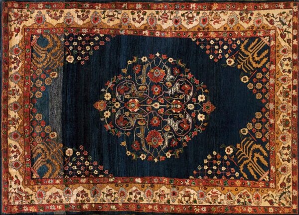 Dark indigo rug featuring a large floral medallion surrounded by elaborate cream, red, and gold borders.