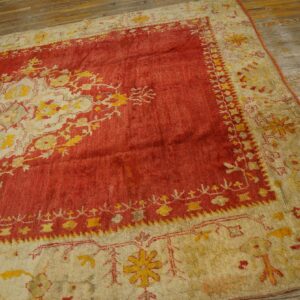 Red and cream rug with a yellow traditional medallion pattern covers rustic wooden plank flooring.