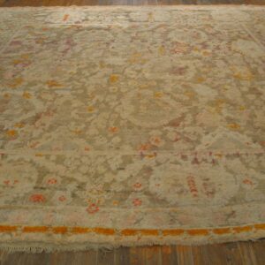 High-pile abstract rug in beige, taupe, orange, and pink colors, resting on dark wood floors.