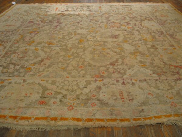 High-pile abstract rug in beige, taupe, orange, and pink colors, resting on dark wood floors.