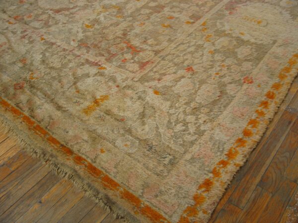A textured beige rug with high pile, orange accents, and pink pattern rests on rustic wood floors.