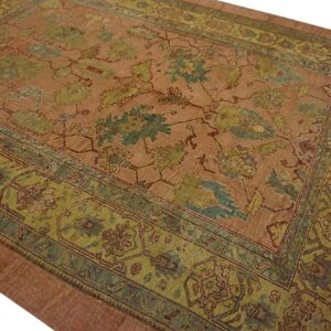 Low-pile rug with a rust field and highly ornate green and blue-green traditional border patterns.