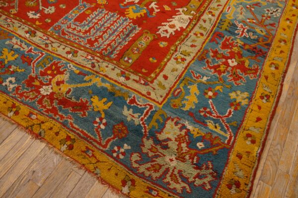 Textured, high-pile rug detail featuring red, blue, and gold traditional patterns over light wood plank flooring.