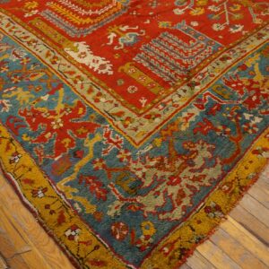 Close-up of a high-pile rug showing red, teal, and gold tribal patterns over rustic wood planks.