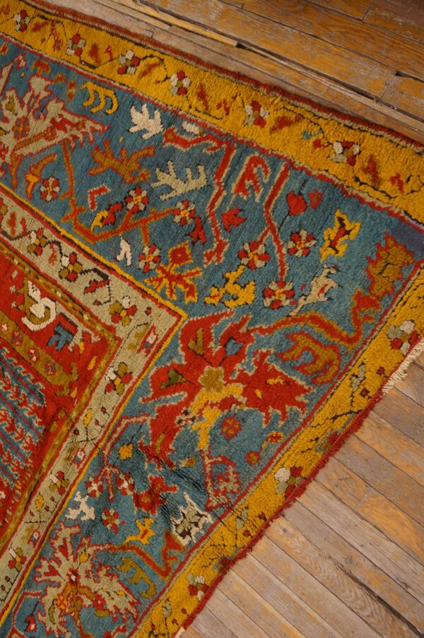 Red and turquoise high-pile rug with yellow borders and stylized patterns on rustic wood flooring.