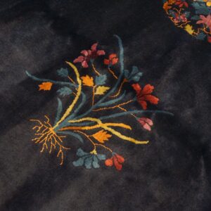 Plush dark blue rug with a colorful floral cluster and a visible yellow patterned border.