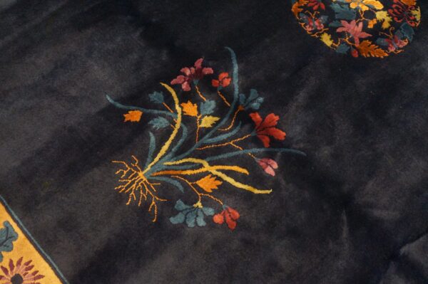 Plush dark blue rug with a colorful floral cluster and a visible yellow patterned border.