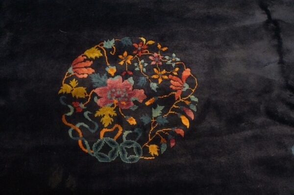Plush dark navy rug featuring a round floral medallion in yellow, rust, rose, and teal colors.