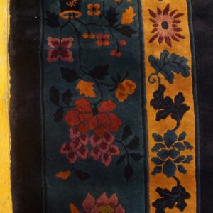 A multicolored high-pile rug featuring detailed teal and gold floral borders rests on bright yellow wood planks.