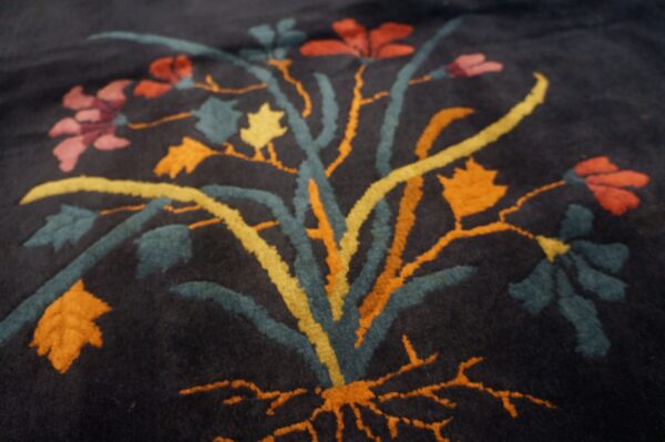 Plush navy rug detail showing a dimensional floral pattern in teal, orange, yellow, and pink.