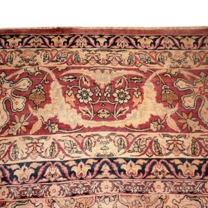 Detailed view of a dense, traditional rug pattern in beige, maroon, and navy blue.