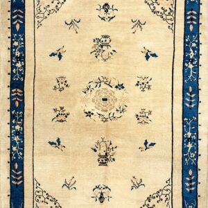 Ivory rug with scattered floral and vessel motifs and a wide, detailed navy blue border.
