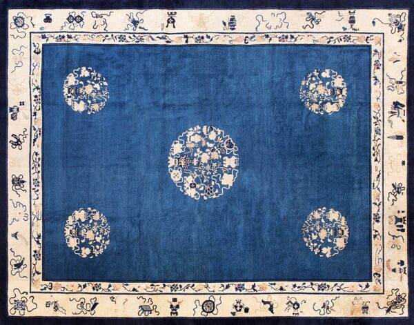 Cobalt blue rug featuring five ivory floral medallions and a broad border with scattered symbolic motifs.