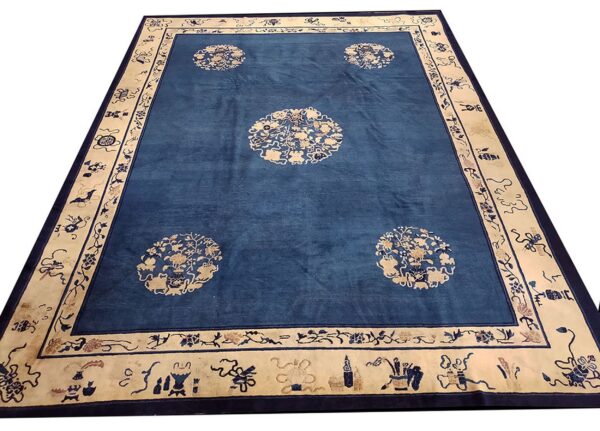 Large blue rug with four cream floral medallions and a wide ornamental cream border.