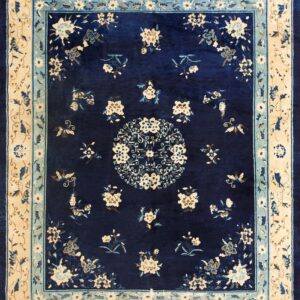 Plush, deep navy blue rug featuring cream and light blue floral patterns and a wide triple border design.