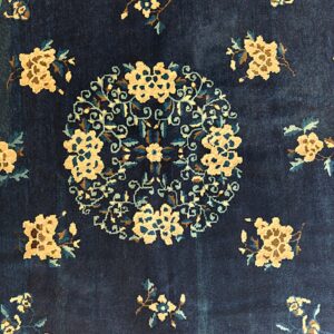 Navy blue rug featuring a circular tan and teal floral medallion surrounded by scattered sprays.