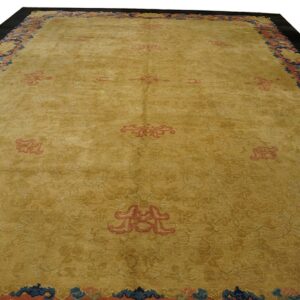 Golden yellow area rug with salmon medallions and a wide blue and coral patterned border.