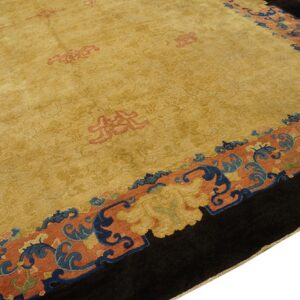 High-pile gold rug with large salmon and blue scrolled borders and a deep black edge.