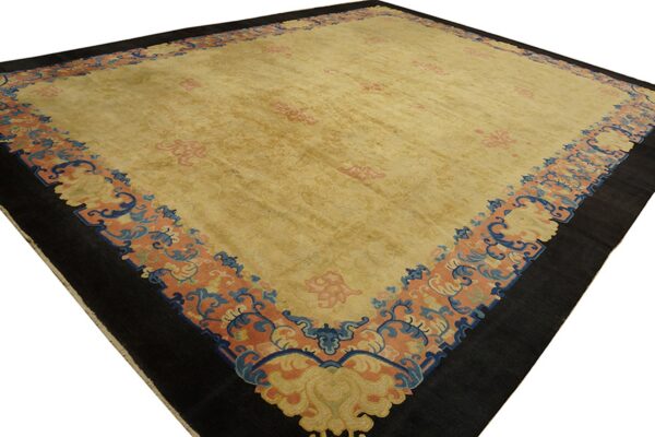 Gold area rug featuring subtle pink patterns and a wide scrolling border of coral, dark blue, and black.