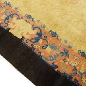 Golden yellow rug field bordered by a rust band with blue and yellow stylized floral motifs.