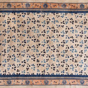 Beige rug featuring scattered blue leaves and a detailed rust and navy blue border.